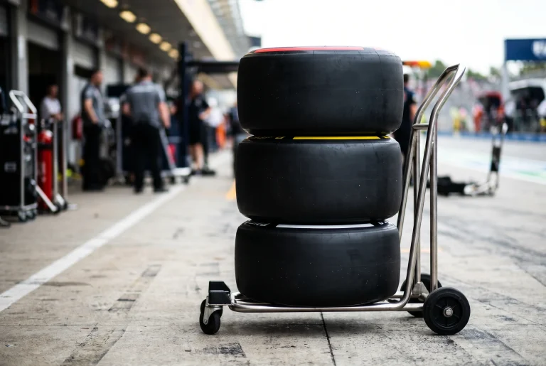 Stack of F1 racing tyres on a pit-lane trolley showing soft, medium and hard compound colour bands
